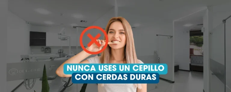 Mujer cepillándose los dientes en una clínica dental con advertencia sobre el uso de cepillo de cerdas duras